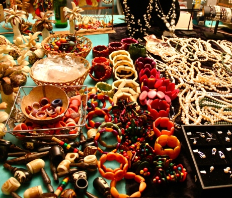 Tables are full of brightly colored beads, pearls, gems and jewelry at the market at Grand Case in St. Martin